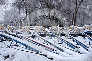 Roller coaster cowered with snow in amusement park in winter