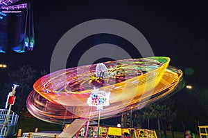 Roller coaster in motion, amusement park at night. Long exposure