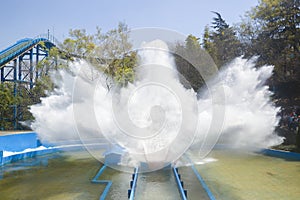 Roller coaster splashing water with blue sky