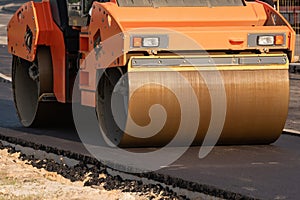 roller compacts asphalt on the road during the construction of the road. compaction of the pavement in road construction. rink