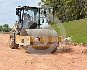 Roller packs highway ramp under construction