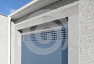 Roller shutter gate. Metal roller garage door as background. Automatic electric roll-up garage gate. Garage with blue rolling