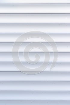 Roller shutter texture. Background with metal stripes in white. Iron roller shutters of white color.