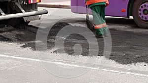 Roller and workers on asphalting and repair of city streets. Close-up.