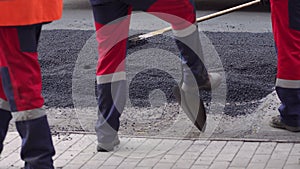 Roller and workers on asphalting and repair of city streets. Close-up.