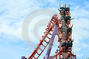 Rollercoaster with people riding along the track in the amusement park.