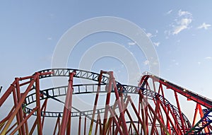 Rollercoaster ride in an amusement park against a blue sky