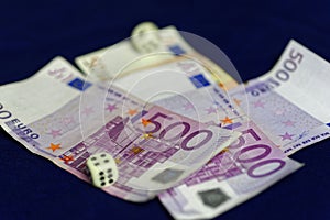 Rolling dice on five-hundred Euro banknotes