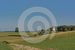 Rolling hills of flemish ardennes with historic windmill