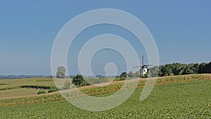 Rolling hills of flemish ardennes with historic windmill