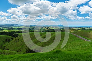 Rolling hills and meadows under a blue sky filled with clouds