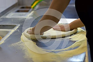 Rolling out pizza bases from dough with pizza hands