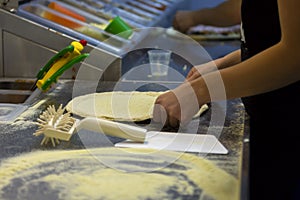 Rolling out pizza bases from dough with pizza hands