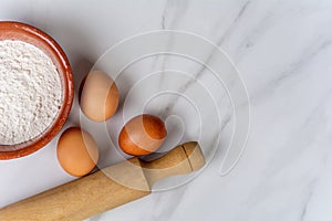 Rolling pin, cup of flour and eggs