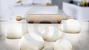 Rolling pin and fresh doughs standing on white table. 3D illustration