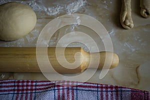 Rolling pin and homemade dough on kitchen table