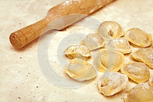 Rolling pin and ravioli on table