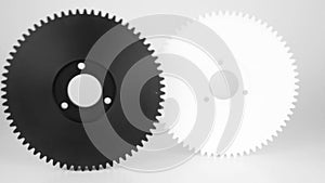 Rolling plastic gears in white and black, isolated on a white background.