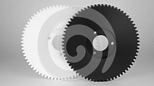 Rolling plastic gears in white and black, isolated on a white background.