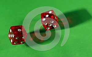 Rolling red dice on green table