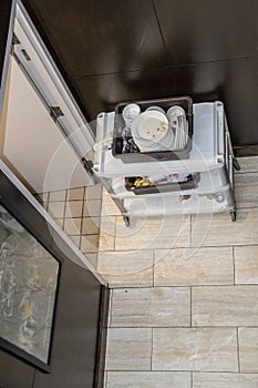 Rolling service cart with trays of dirty dishes sitting in hallway of hotel