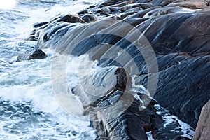 Rolling wave slamming on the rocks photo