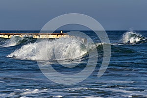 Rolling waves crashing near breakwater