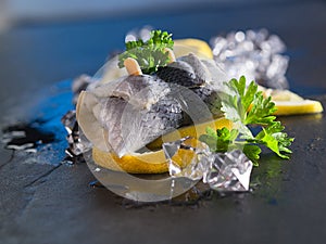 Rollmop herring on lemon slices and ice cubes