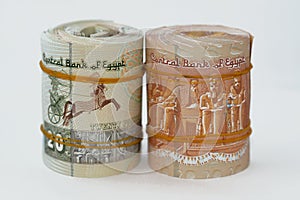 Rolls of 1 EGP LE one Egyptian pound cash money bills and 5 LE five pounds rolled up with rubber bands with a image of Abu Simbel