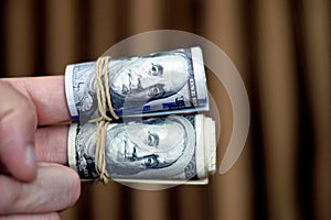 Rolls of 100 one hundred dollar banknote currency cash money old and new series rolled up with rubber bands with the portrait of