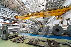 Rolls of aluminum and crane in production shop of plant