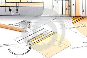 Rolls of architectural blueprints and house plan with pencil