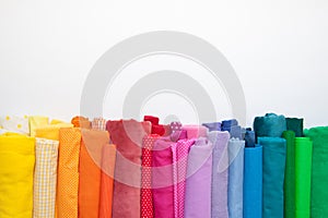 Rolls of bright colored fabric on a white background.