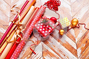 Rolls of Christmas wrapping paper with ribbons, gifts and bolls