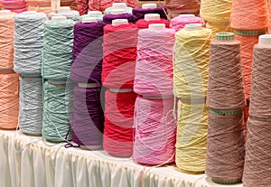 rolls of colored cotton wool thread during sale in a haberdashery counter