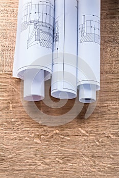 Rolls of construction drawings on wooden oaken