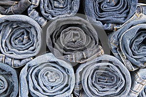 Rolls of different worn blue jeans stacked