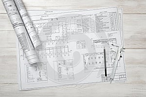 Rolls of drawing sketches lie on a wooden surface.