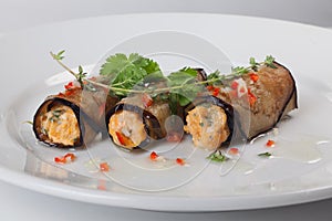 Rolls of eggplant with cheese and greens, sweet pepper, close-up for menu