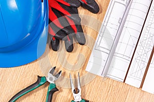 Rolls of electrical drawings, protective helmet with gloves and work tools