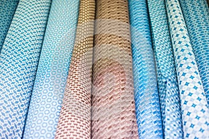 Rolls of fabric with various patterns on display in a sewing store