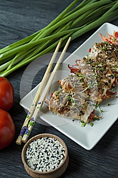 Rolls with fresh chicken breast with greens, carrot slices, bell peppers on a dark cutting board. The concept of healthy homemade