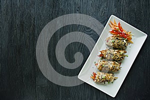 Rolls with fresh chicken breast with greens, carrot slices, bell peppers on a dark cutting board. The concept of healthy homemade