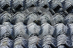 Rolls of galvanized steel wire mesh with a large cell and twisted pattern close-up. In the category of texture, screen