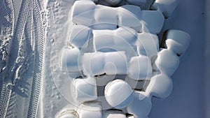 Rolls of hays covered with thick white snow in Finland