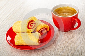 Rolls with jam in saucer, cup with coffee espresso on wooden table