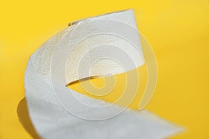 Rolls of new toilet paper lie on a yellow background