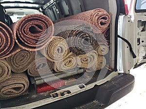 Rolls of old carpet and padding in the truck for installation