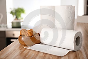 Rolls of paper towels with tasty pastry on kitchen table