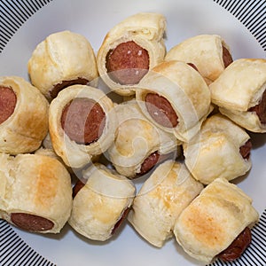 Rolls of puff pastry filled with wurstels